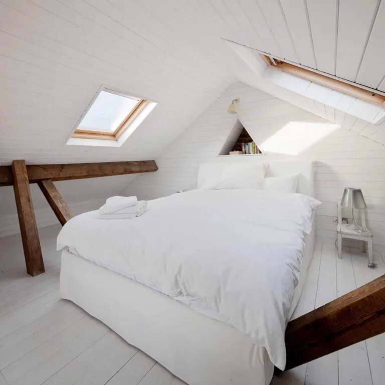 Luxury loft conversion bedroom featuring exposed wooden beams in Wanstead