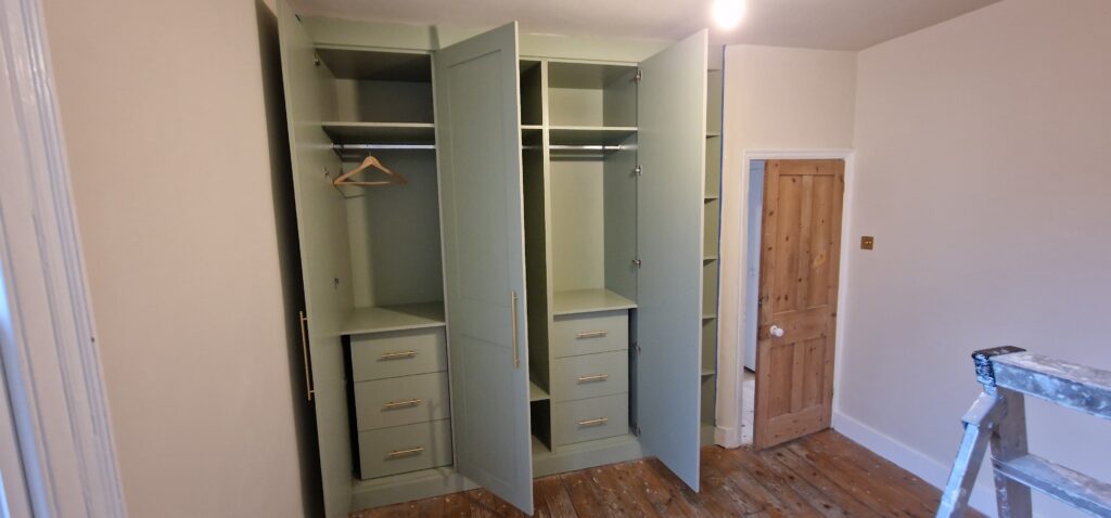 Fitted green wardrobes and custom bedroom storage solution