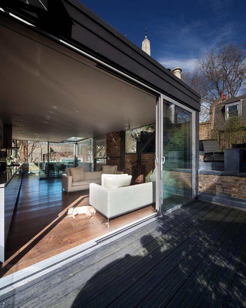 Open-plan living space renovation with large glass sliding doors in Old Street