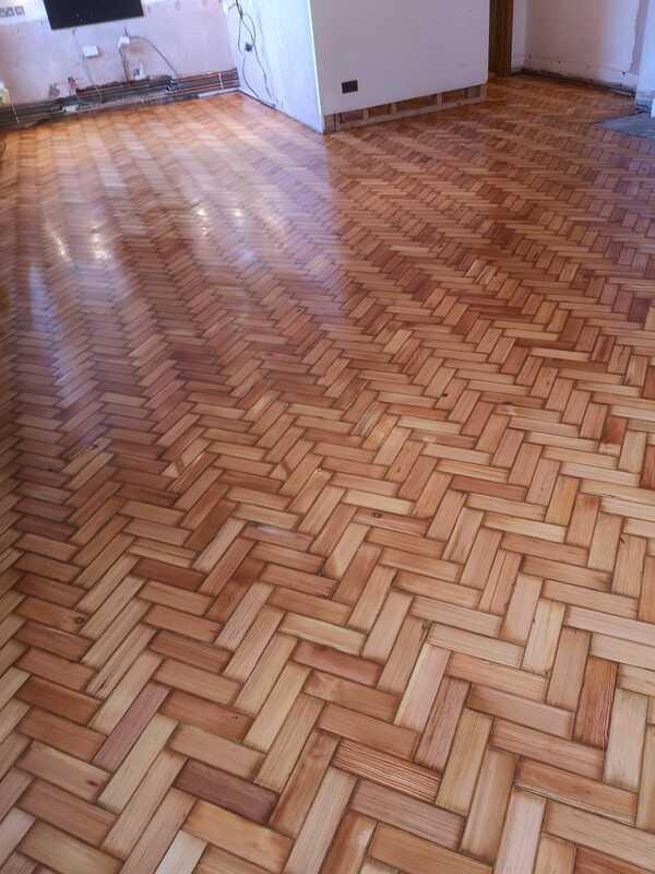 Luxury herringbone parquet wood flooring reinstallation and sanding detail.